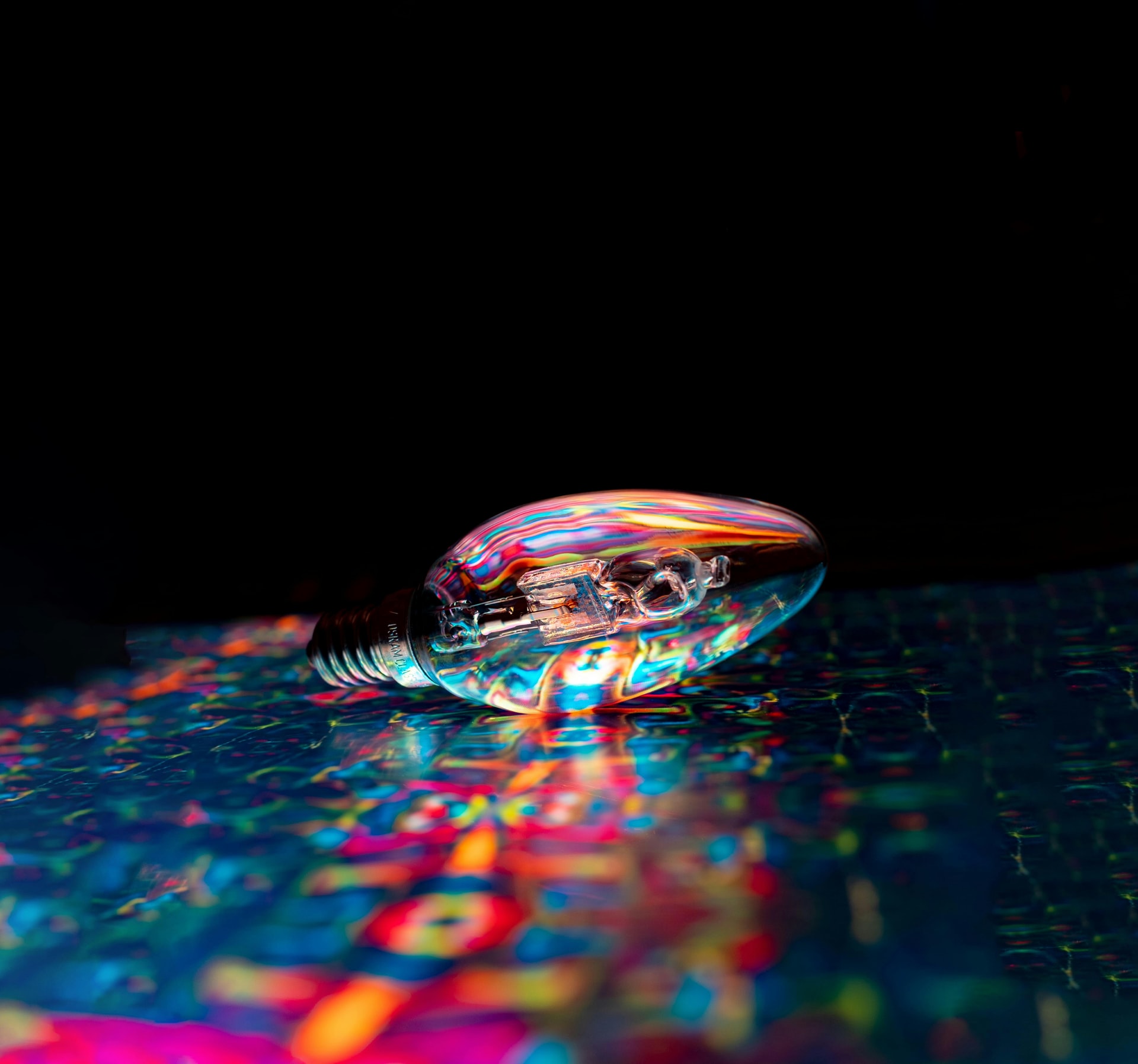 multicoloured light bulb on multi coloured surface