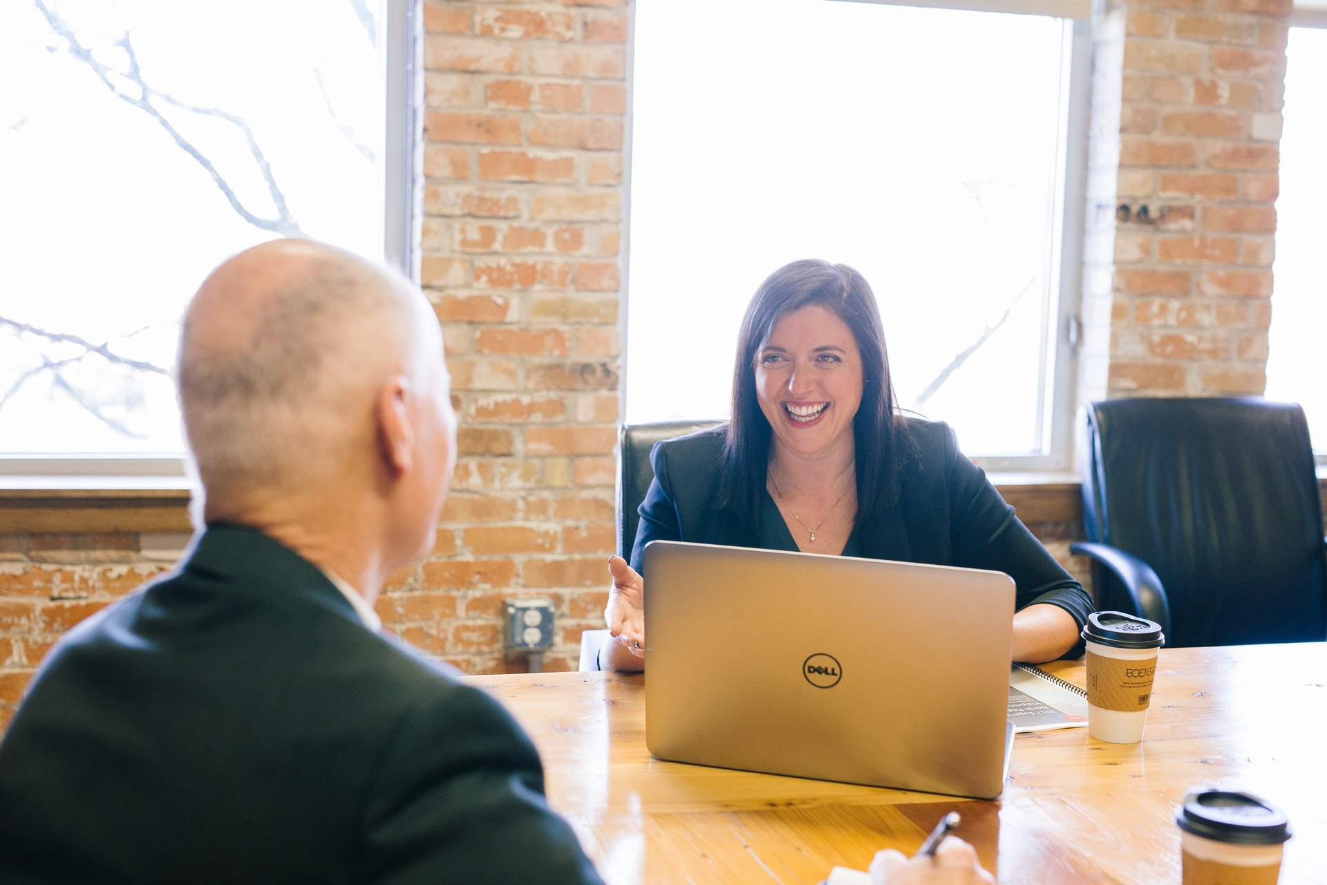 Female and male business people sat at a desk with a laptop