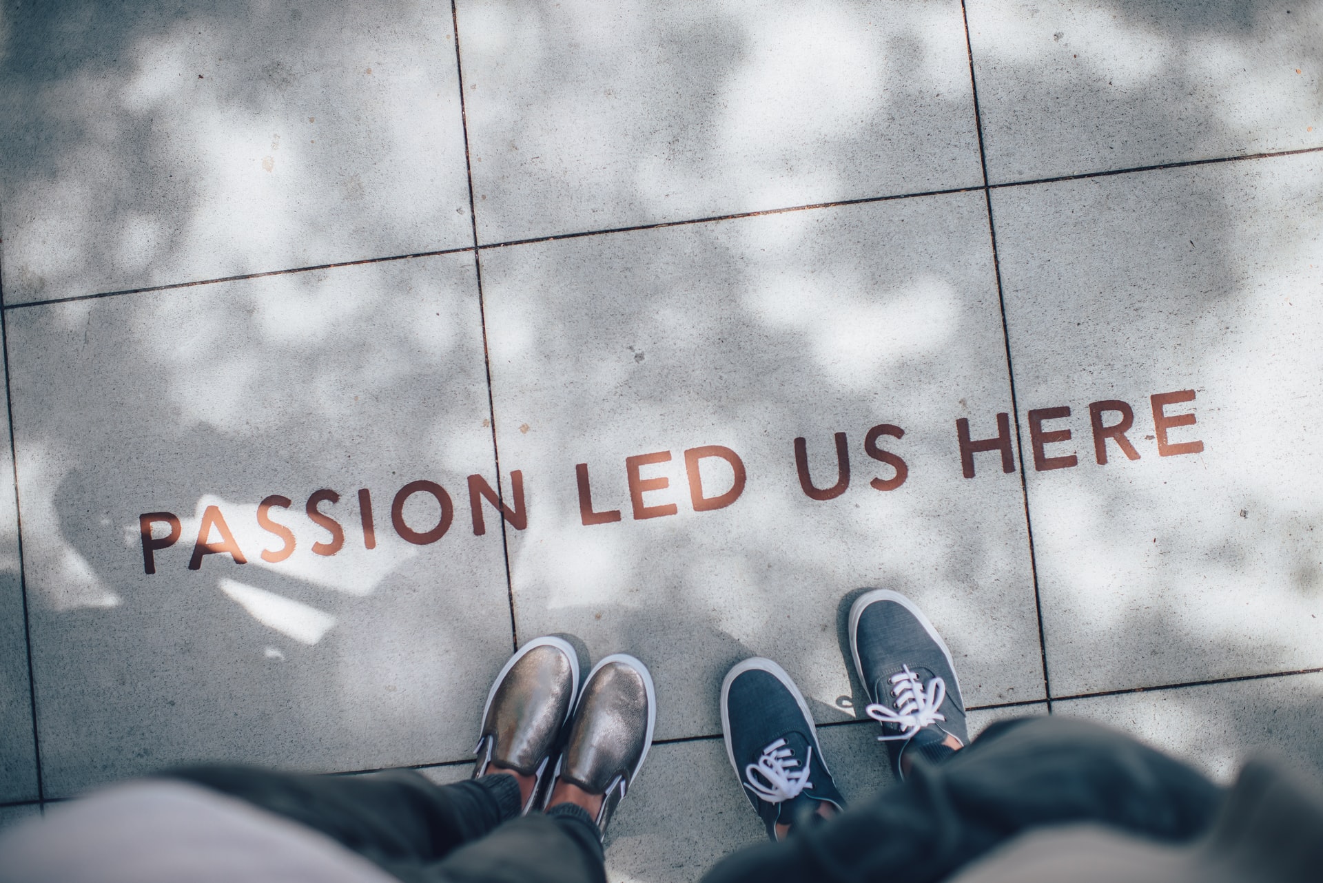 photo of the feet of two people next to the words passion led us here.