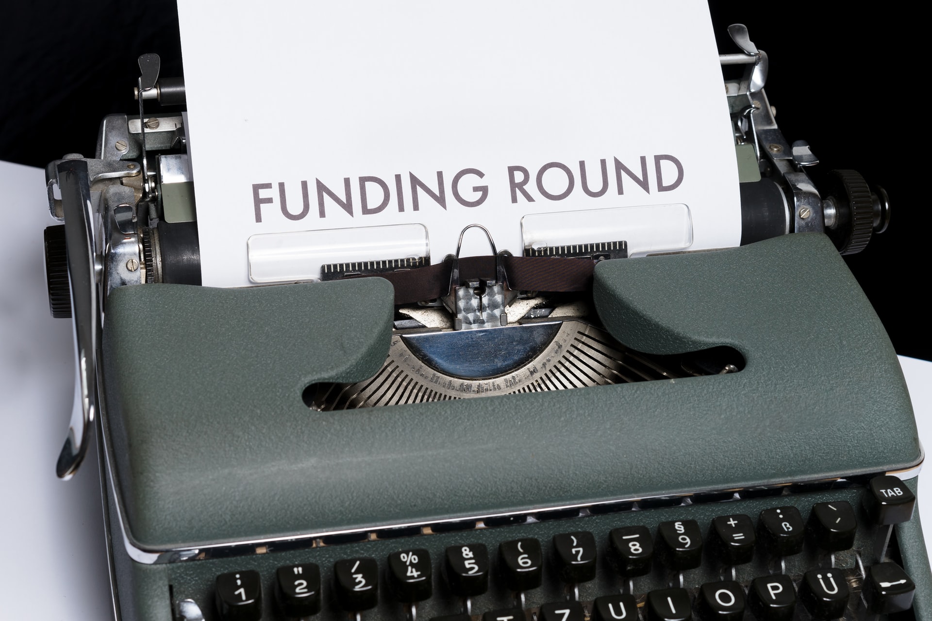piece of paper in a typewriter with the words Funding Round typed on it