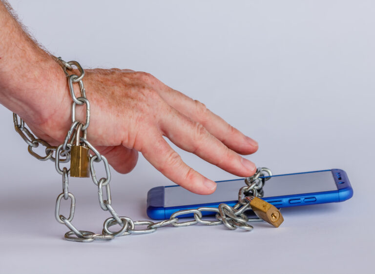 Man chained to his smartphone to which he has an addiction