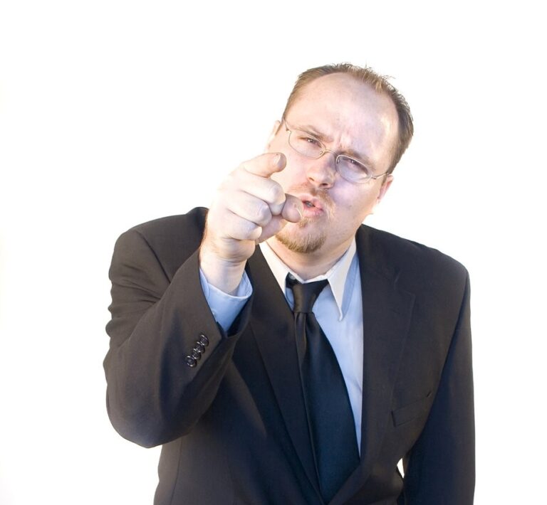 Angry boss pointing and leaning forward