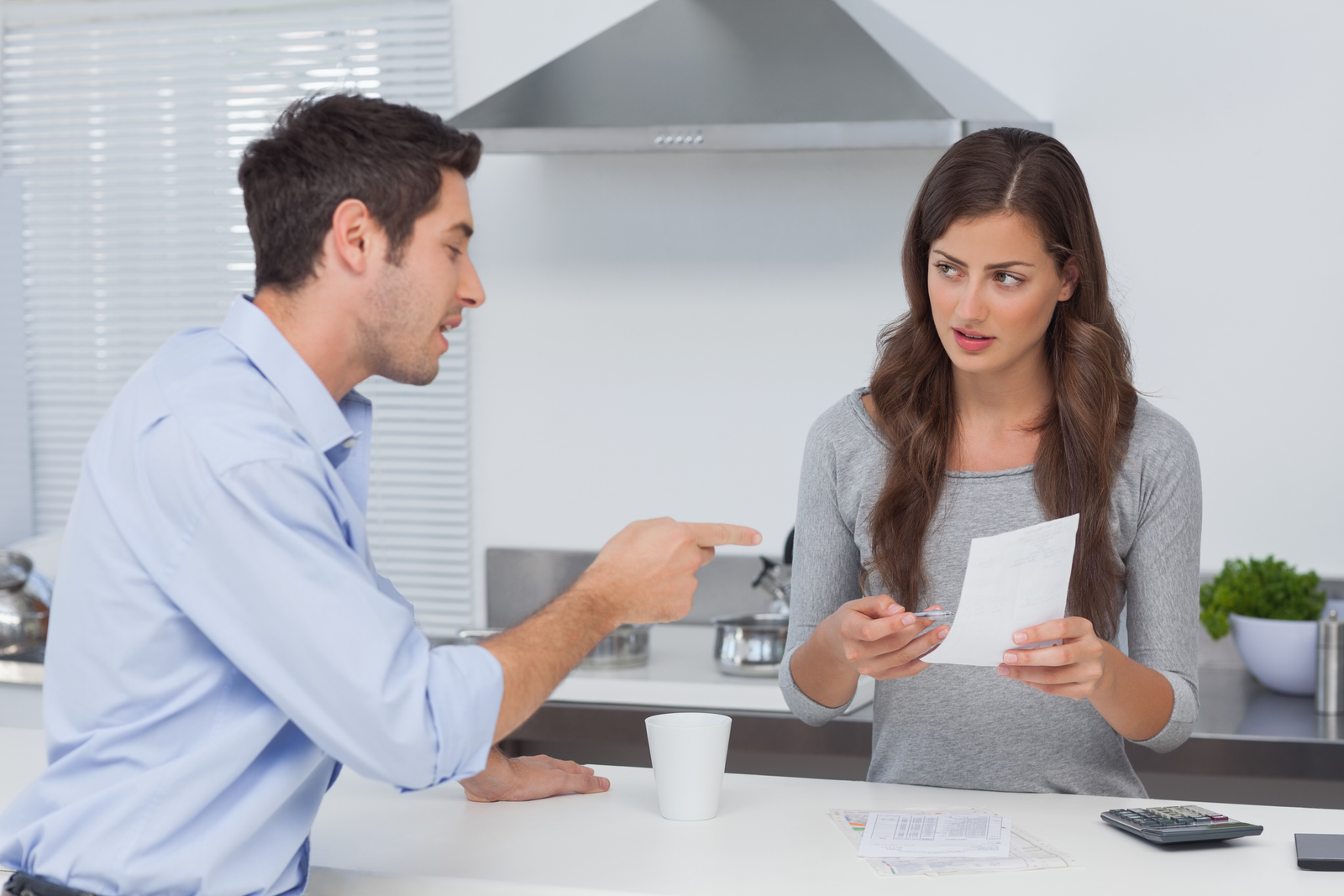 Man and woman in kitchen at home discussing finances for bootstrapping a startup business.