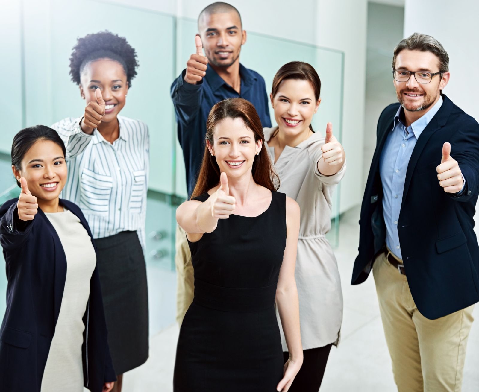 High-angle-portrait-of-a-group-of-business-people-standing-together-and-showing-their job satisfaction with a-thumbs-up-in-the-office