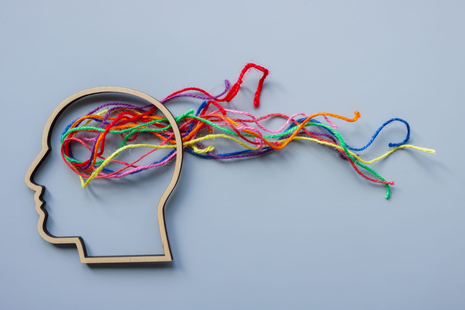 a head with multicoloured string flowing out the top to illustrate neurodivergence