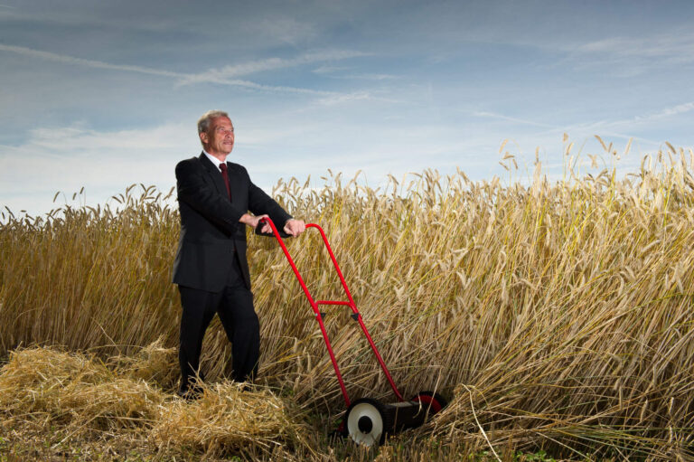 Business man in the middle of a field of wheat finding his business mojo