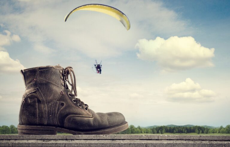 A boot on a wall and paraglyder in the distance. Early retirement.